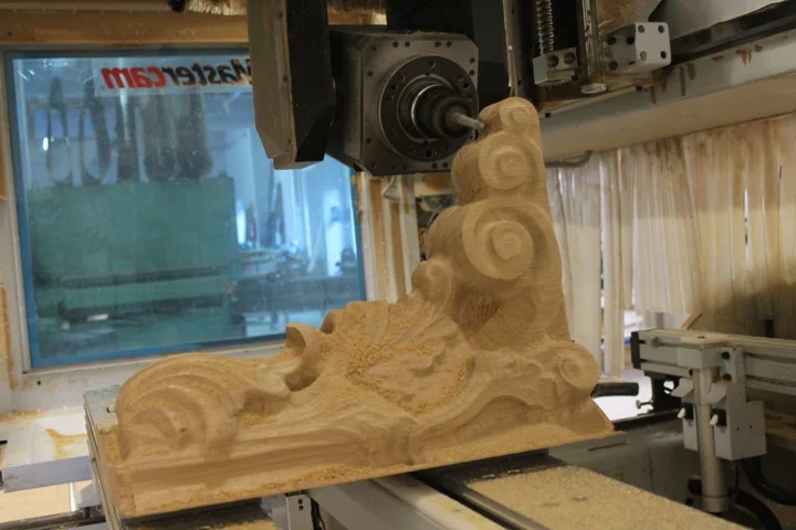 A laterally oriented milling tool machines a Corinthian capital in oak