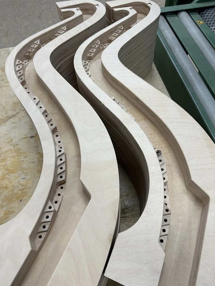CNC-gefertigte Musikinstrumentenbauteile mit geschwungenen Konturen und vorbereiteten Bohrungen