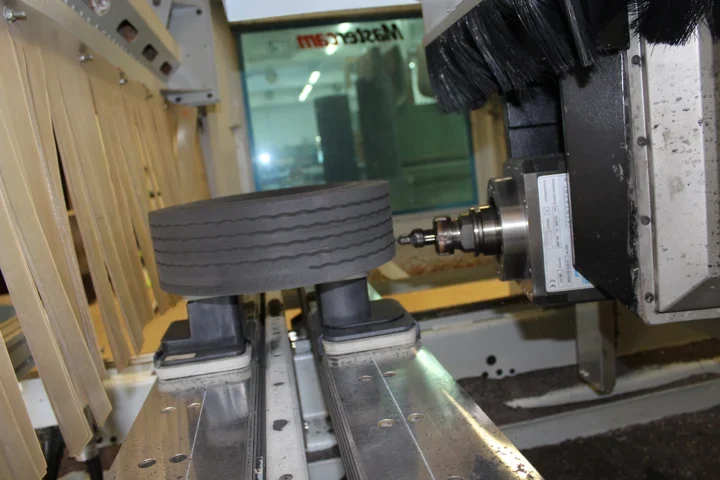 Side milling of a continuous tyre tread profile on a clamped workpiece