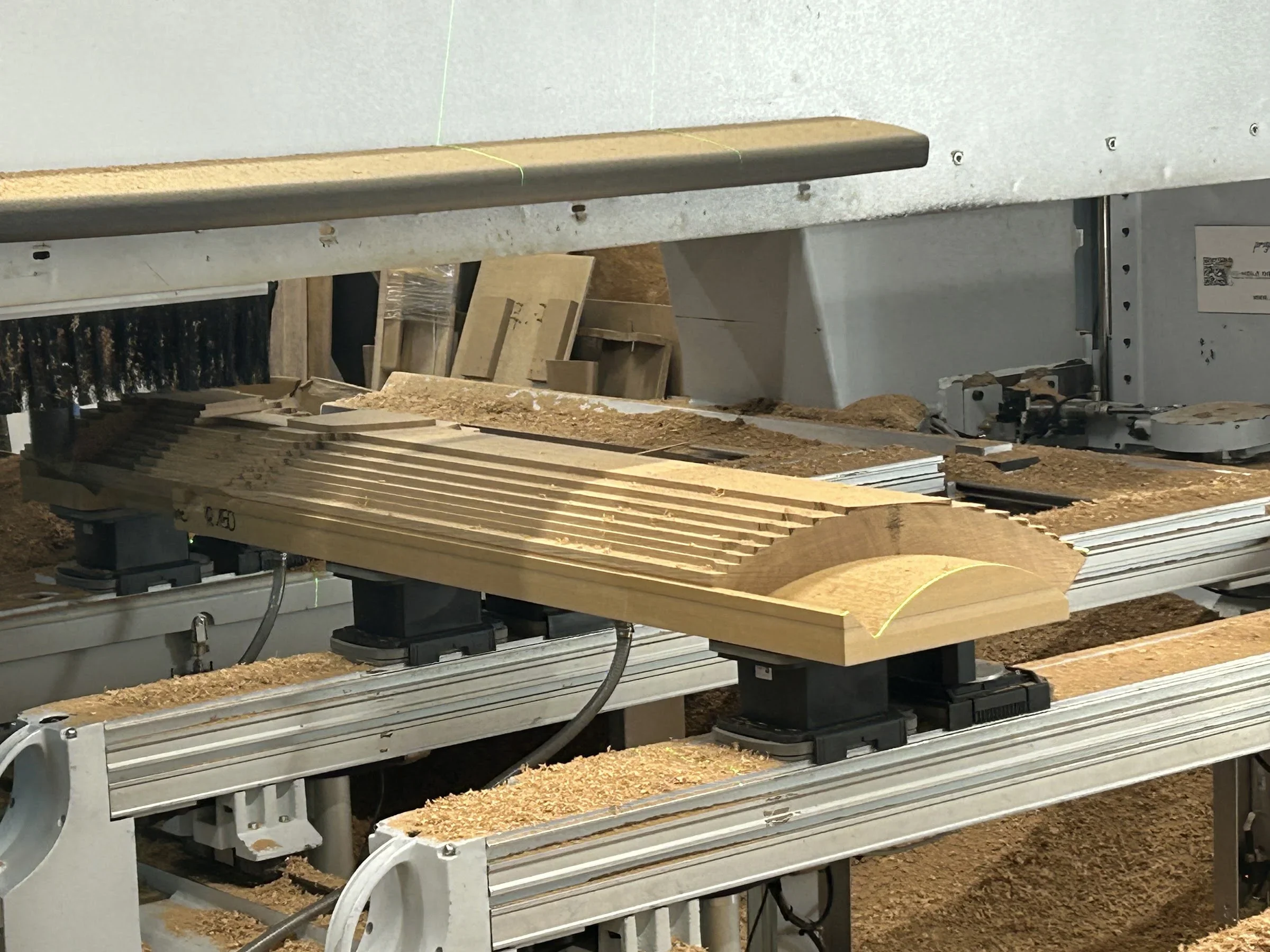 Curved staircase handrail component during CNC manufacturing.